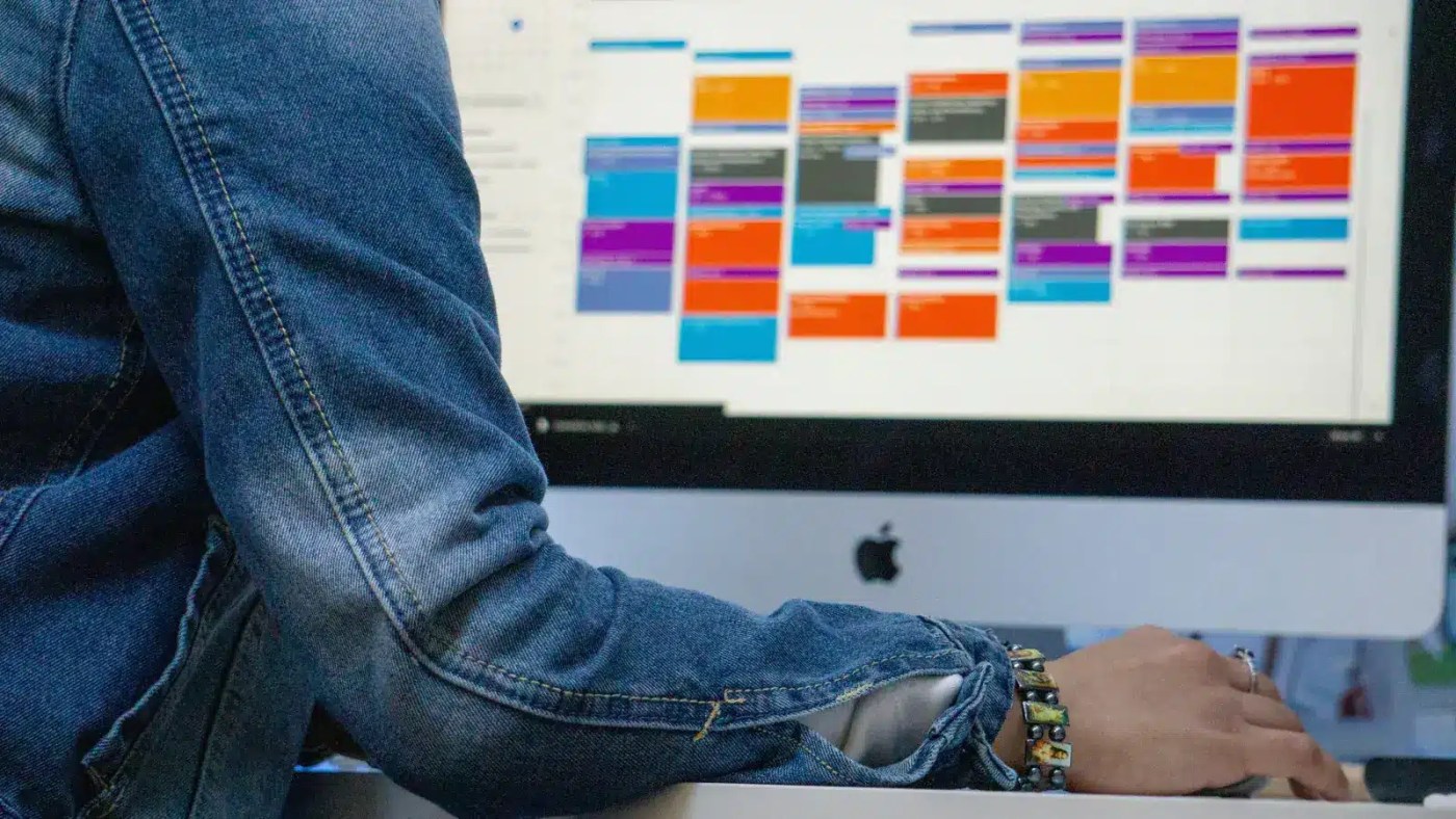 Manager reviewing a colour-coded work schedule on screen while evaluating an Agendrix alternative