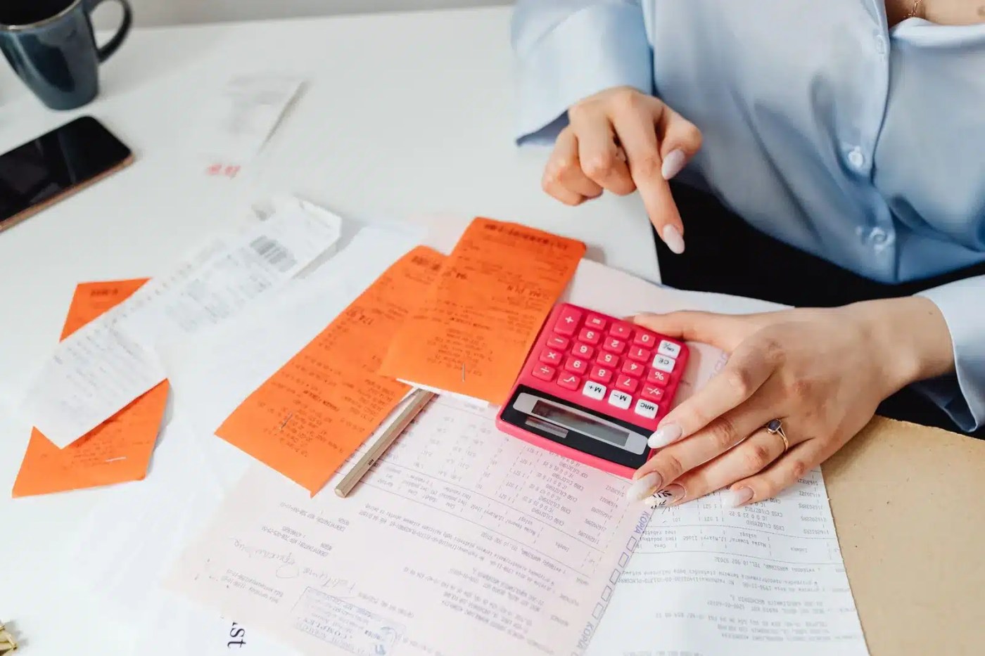Calcul des heures supplémentaires au Canada avec une calculatrice, des reçus et des documents de paie étalés