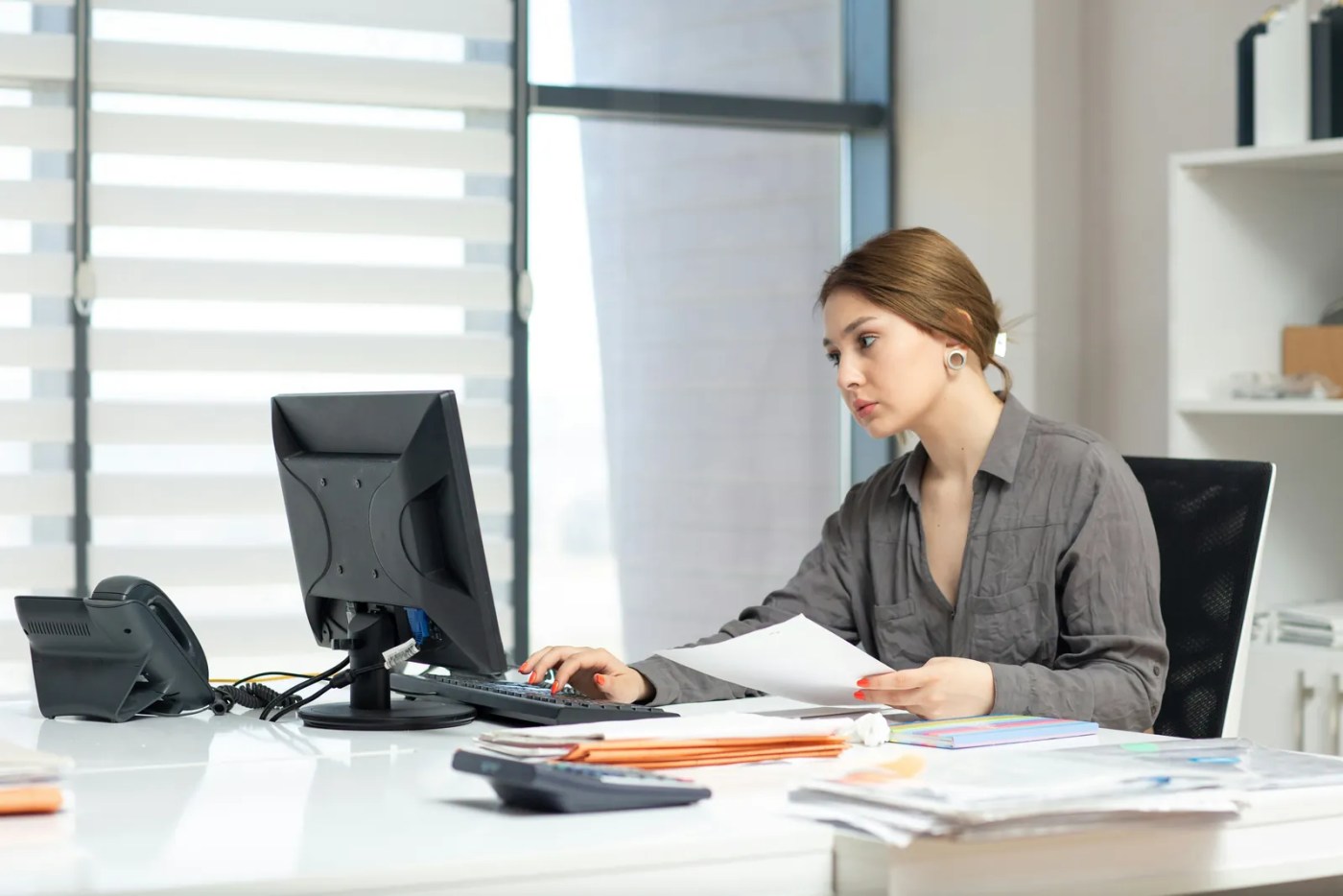 Professionnelle des ressources humaines comparant des documents pour choisir la meilleure solution SIRH au Canada