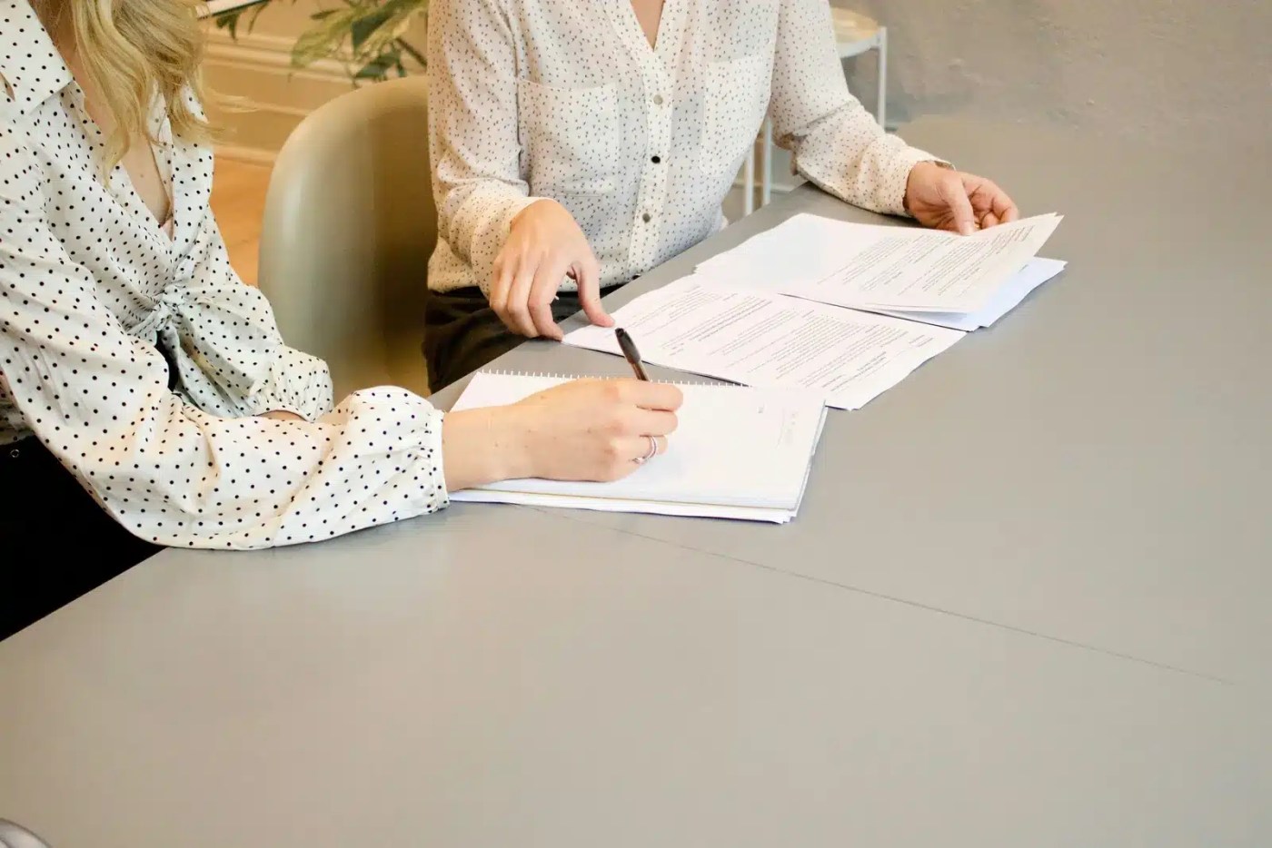 Deux gestionnaires révisant des documents RH et prenant des notes lors d'une rencontre